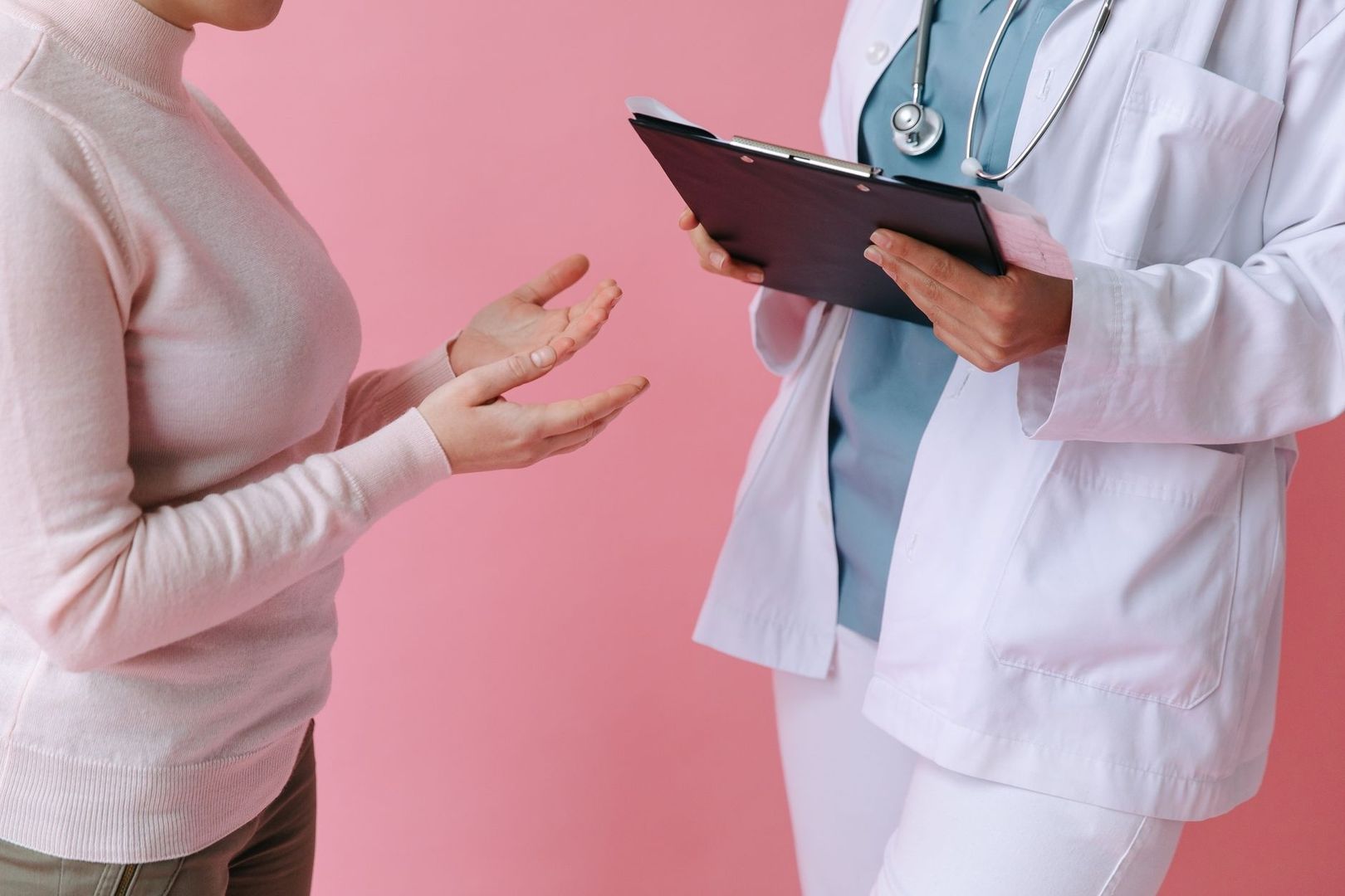 Patient samtalar med läkare som håller i ett anteckningsblock